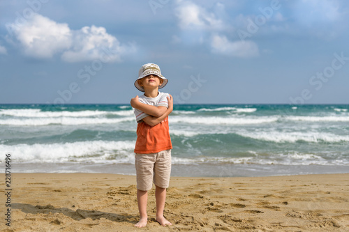 little boy on the beach playing with sand