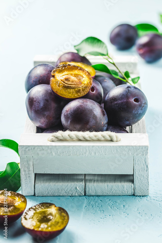 Obraz na płótnie Ripe plums in a box. Selective focus, space for text.