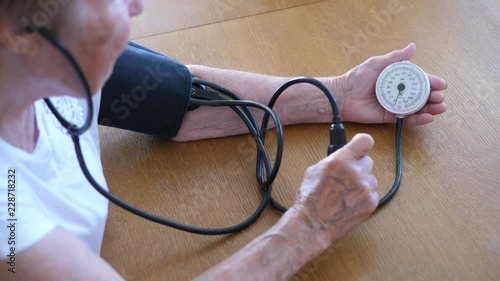 Grandmother Checking Blood Pressure With Tonometer At Home photo