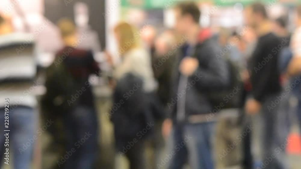 Many people walk inside the mall exhibition store. Blurred Background Many people walk inside the mall exhibition store. Blurred Background