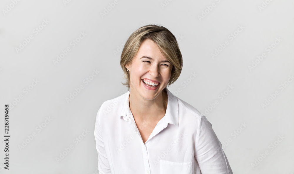 Happy young blonde woman wearing white shirt smiling portrait against white background Happy young blonde woman wearing white shirt smiling portrait against white background