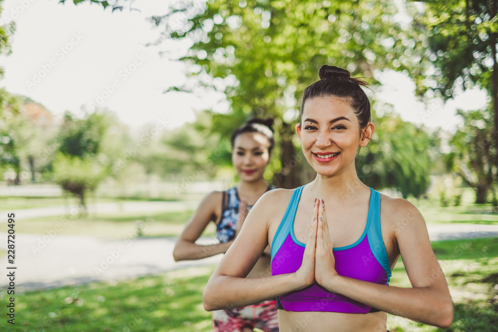 Fototapeta premium Group of woman family doing yoga pose/meditation at outdoor green park/garden with happy feeling in the morning