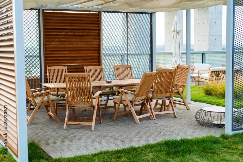 Outdoor patio with wooden chairs and table - obrazy, fototapety, plakaty 