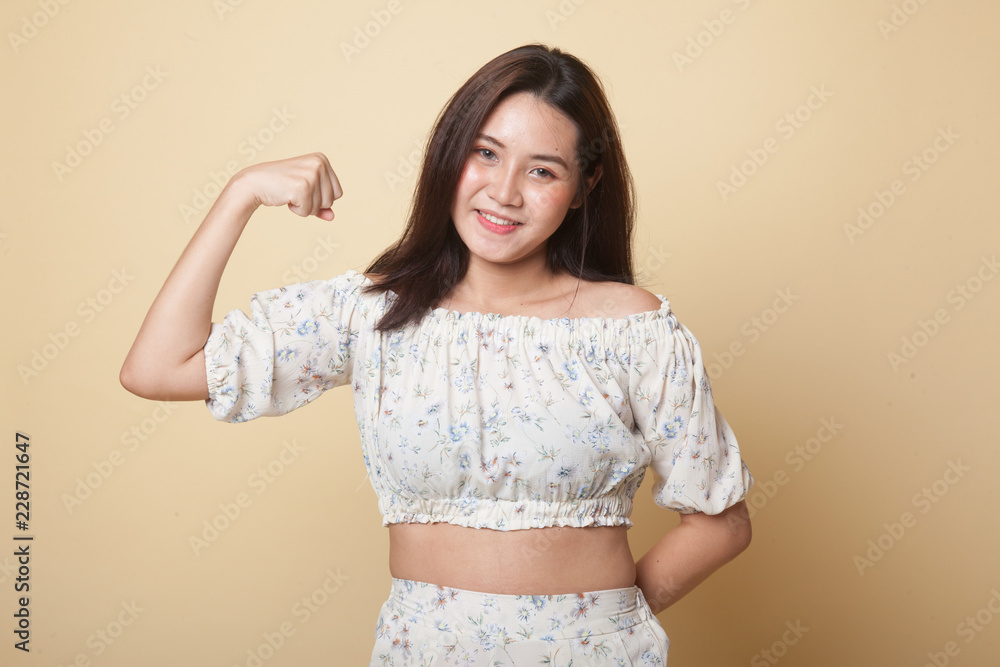 Obraz premium Beautiful young Asian woman flex bicep.