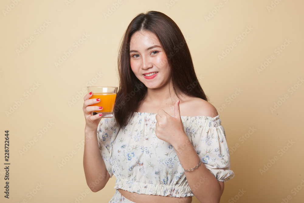 Young Asian woman thumbs up drink orange juice. Young Asian woman thumbs up drink orange juice.