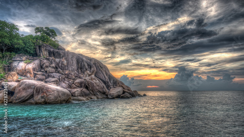 Dramatischer Sonnenuntergang mit Felsklippen am Meer