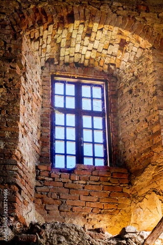 An old wooden window in an ancient castle in a brick wall_