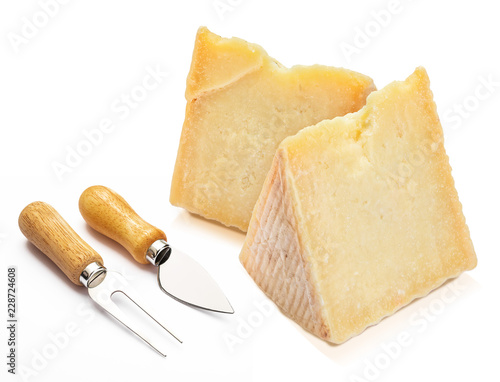 Cured sheep cheese (Manchego type) in wedge and cutlery. Isolated on white background.