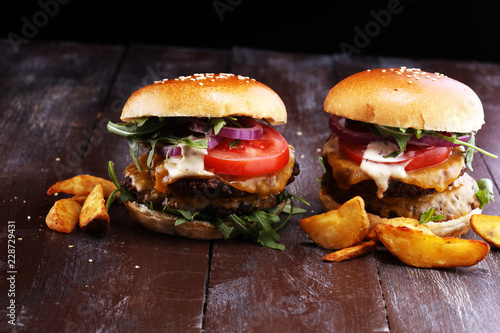 Tasty fresh meat burgers with salad and cheese and potato wedges. Homemade angus burger.