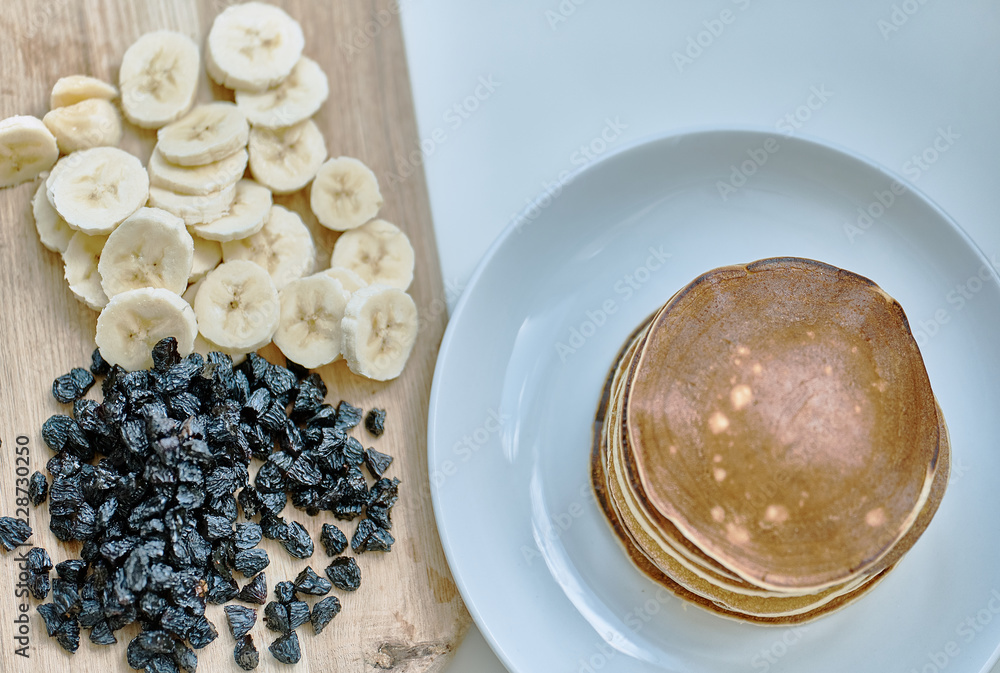 Sliced bananas, blueberries, raisins, pigeons, lie on the table. Sliced bananas, blueberries, raisins, pigeons, lie on the table.
