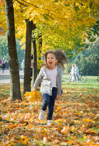 Happy girl run in autumn park