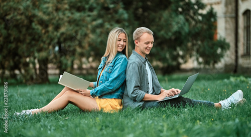 The guy and the girl look at the laptop together.