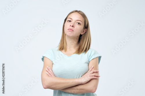 Portrait of beautiful young woman with arms crossed isolated over white background