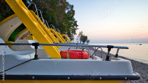 Obraz na płótnie Tretboot am Strand mit Rutschbahn und Rettungsring w salonie