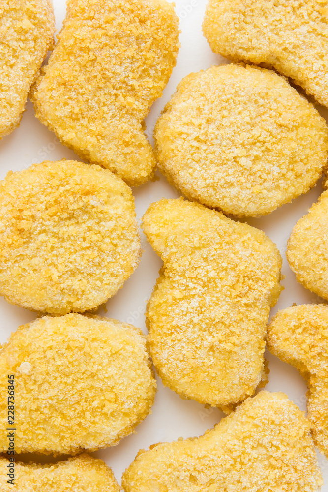 Frozen nuggets on a white background. Several chicken nuggets in breading close-up on a white background. Frozen nuggets on a white background. Several chicken nuggets in breading close-up on a white background.