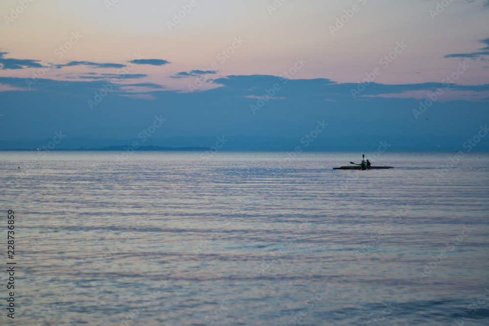 Kanufahrer auf See bei Sonnenuntergang
