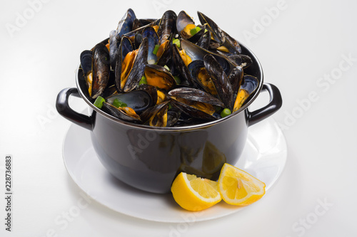 Black pan with cooked with green onion, parsley marinated high quality mussels