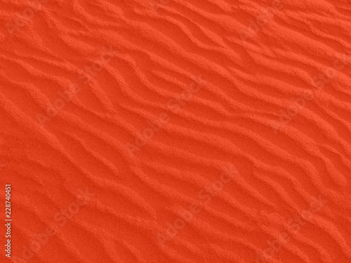 texture of red sand waves on the beach or in the desert. the ripples of the sand is diagonal. photo