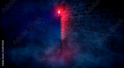 Fototapeta Naklejka Na Ścianę i Meble -  A dark street, a red lantern, a brick wall, smoke, a corner of the building, a lantern shining. Night scene, club neon light. Night city and neon light.