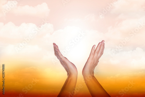 Healing hands in the sky with bright sunburst