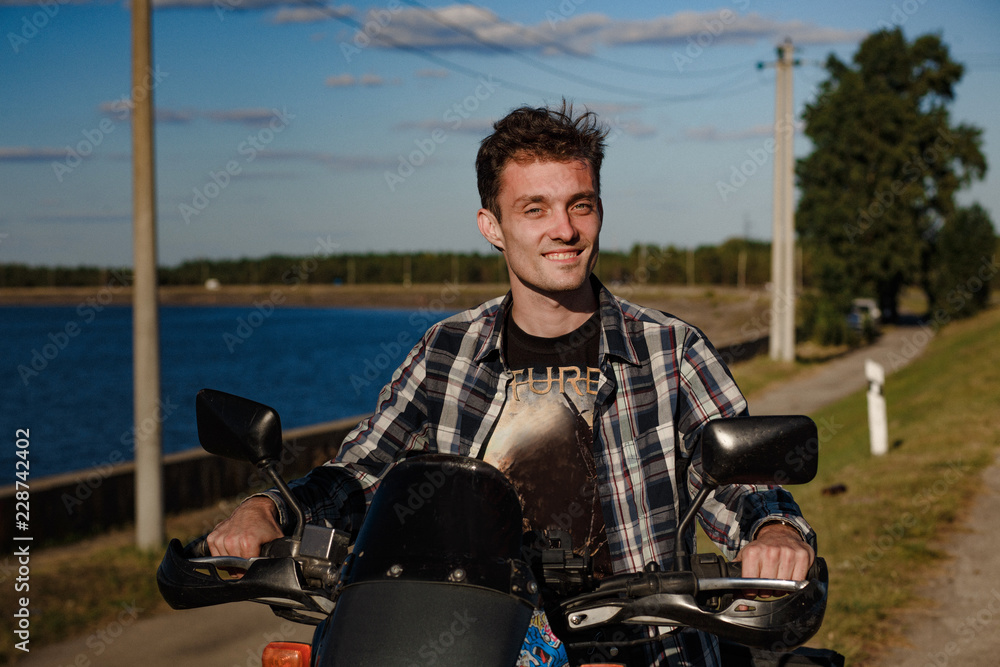 Smiling biker rides a bike. A young biker smiling at the camera