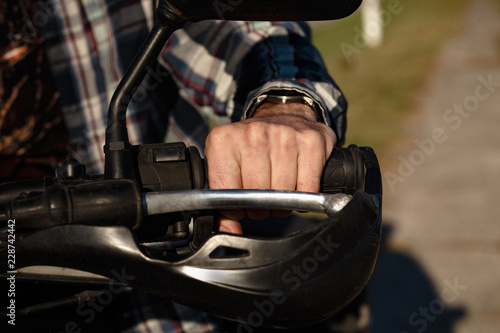 Close shot of biker's bare hand. The hand of a biker is on the brake.