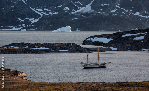 Arctic landscape in summer with high mountains and sailing shiip photo