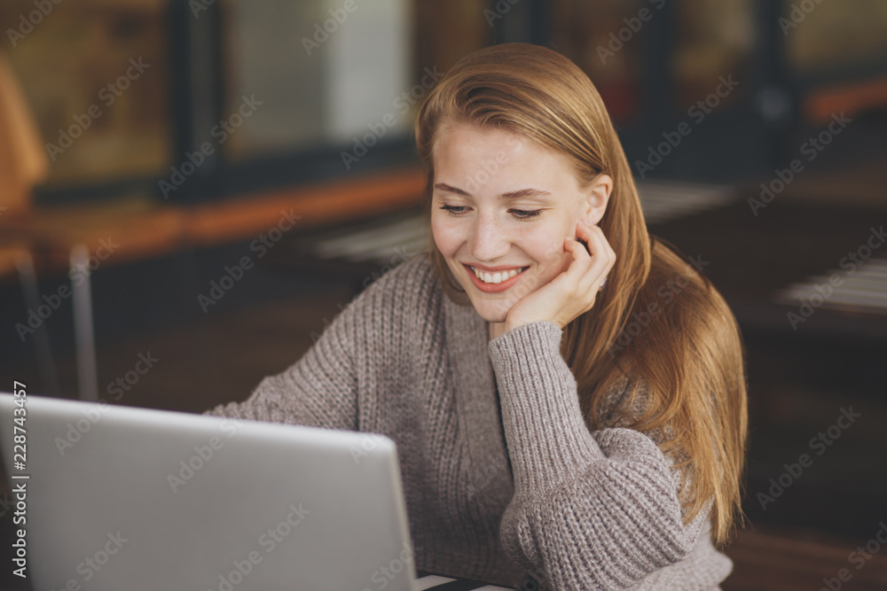Successful female grapic designer watching tutorial about creative ideas at laptop computer during working process in office.Positive student with blonde hair reading business news on netbook Successful female grapic designer watching tutorial about creative ideas at laptop computer during working process in office.Positive student with blonde hair reading business news on netbook