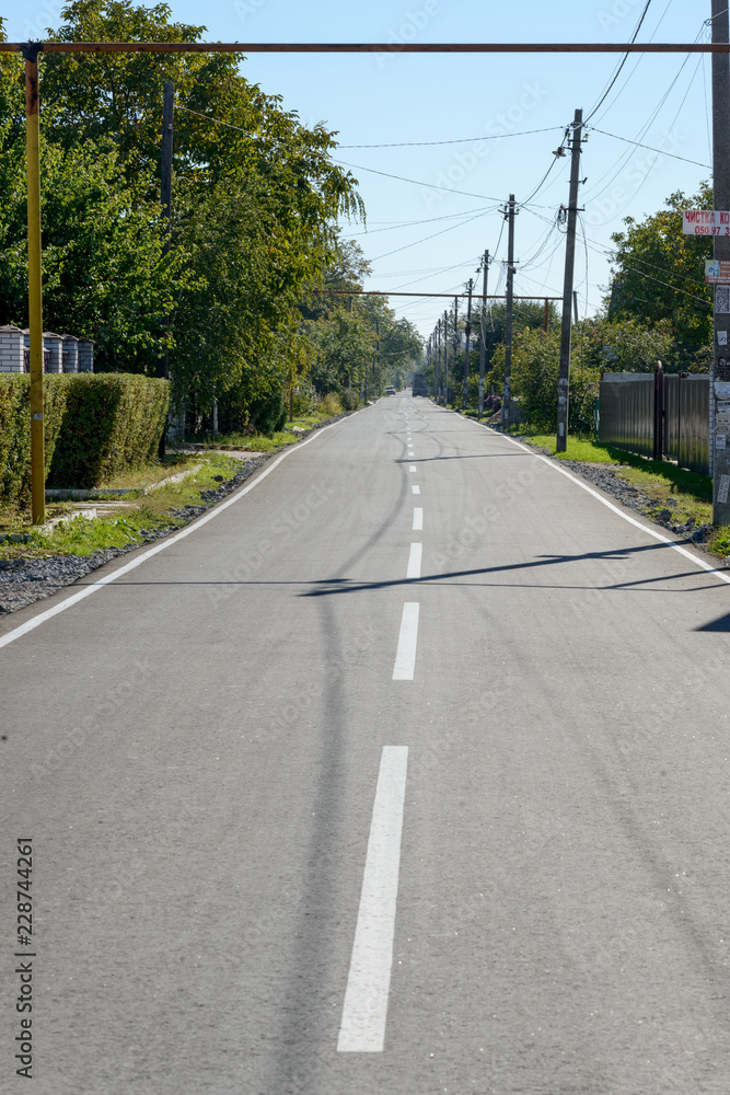 View along estate asphalt road in Ukrainian suburb. View along estate asphalt road in Ukrainian suburb.