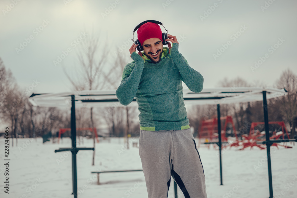 Athletic man listening music in his workout on winter day