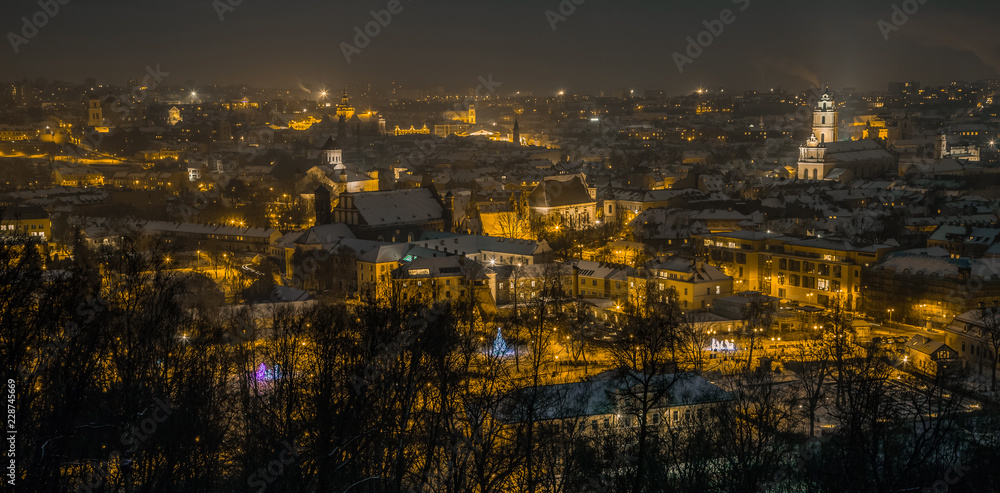 Vilnius Aerial panorama of the Old Town. Vilnius old town panorama at night. Night panorama of the Vilnius Old Town from Hill of Three Crosses, Lithuania. Vilnius winter aerial panorama of Old town.