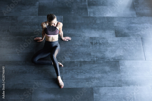 Athletic woman in a gym suit relaxing on the floor top view with copy space for text.