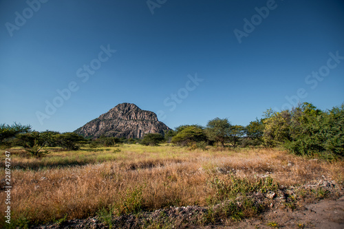 A view of the male hill at Tsodilo Hills  a UNESCO world heritage site featuring ancient San rock paintings. Pictured amid grassy and arid plains