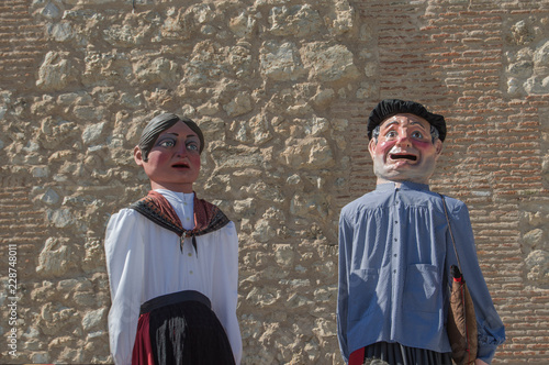 Pareja de Gigantes/
una pareja de gigantes de un desfile de gigantes y cabezudos, aislados sobre un muro de ladrillo photo