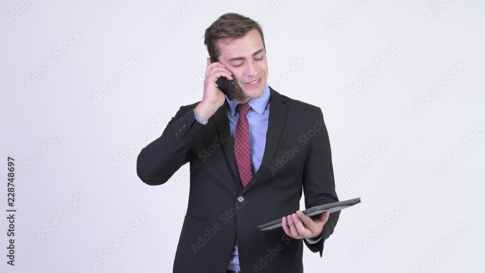 Young happy handsome businessman using phone and digital tablet Young happy handsome businessman using phone and digital tablet