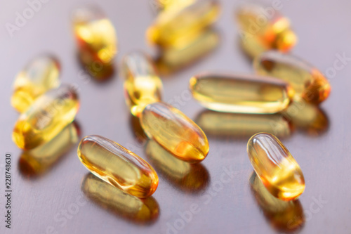 Fish oil omega 3 gel capsules on wooden background
