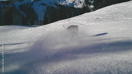 Snowboarder sprays snow into cam while riding 50% speed photo