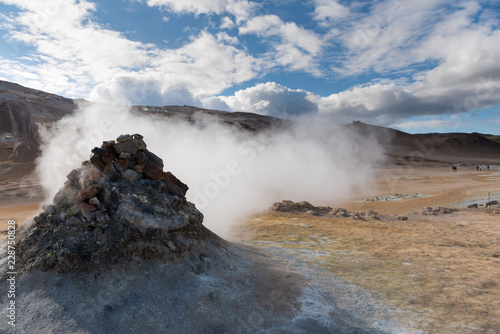 Smoking fumarole near Hverir geothermal area, Myvatn Lake area, Iceland. Geothermal area with smoking fumaroles and mud geothermal springs in Namskard geothermal area, Iceland, Europe