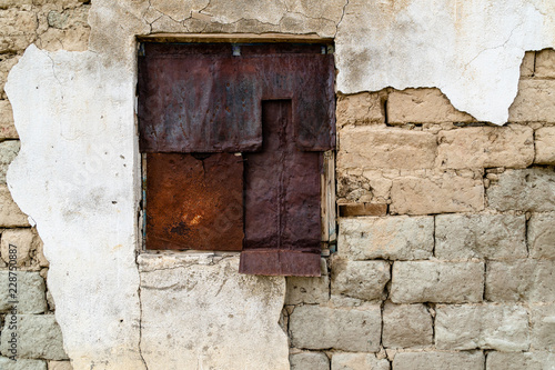 rusty sheets of metal securing a window © vasanth