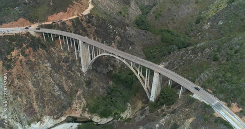 Aerial Drone Stock Video of Bixby Bridge Highway with water and shore below in Big Sur Monterrey California