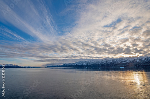 Fototapeta Naklejka Na Ścianę i Meble -  Evening Clouds and Sun in a High Arctic Fjord