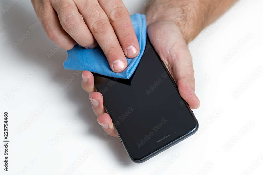 Mężczyzna czyszczący ekran smartfona. Czyszczenie szybki telefonu. Mężczyzna czyszczący ekran smartfona. Czyszczenie szybki telefonu.