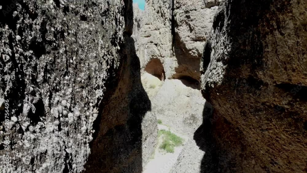 Aerial-Climbing between dark narrow slot canyon walls composed of conglomerate material in a box canyon branching off Maple Canyon in Sanpete county, Utah Aerial-Climbing between dark narrow slot canyon walls composed of conglomerate material in a box canyon branching off Maple Canyon in Sanpete county, Utah