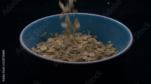 Close up on pouring oatmeal into a bowl in slow motion photo
