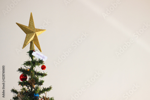 christmas tree and star with a paper written , portuguese text for gratitude