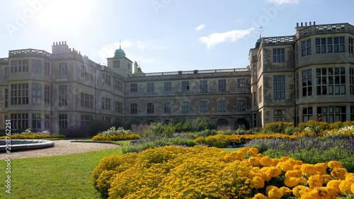 Brisk wind stirs yellow garden plants at Audley End mansion house in Saffron Walden, Essex, England