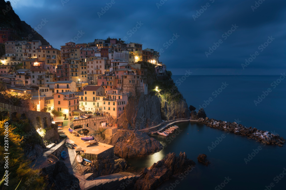 Amazing view of Manarola city at evening light with costal rocks on a foreground. Cinque Terre National Park, Liguria, Italy, Europe