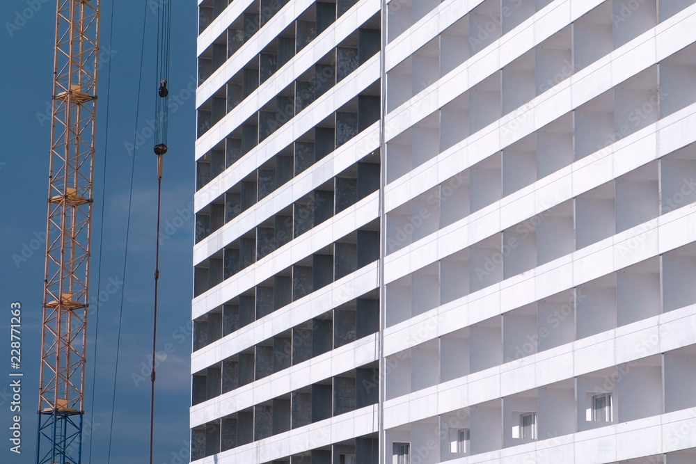 Construction of a multi-storey building. House and construction crane on sky background. Construction of a multi-storey building. House and construction crane on sky background.