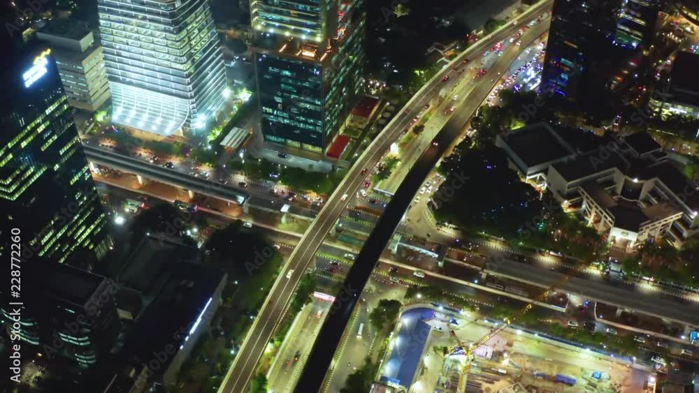 JAKARTA, Indonesia - October 16, 2018: Aerial view of night traffic on the road intersection with light trails of moving vehicles and modern buildings. Shot in 4k resolution JAKARTA, Indonesia - October 16, 2018: Aerial view of night traffic on the road intersection with light trails of moving vehicles and modern buildings. Shot in 4k resolution