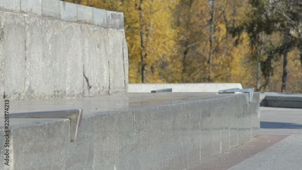 Unrecognizable Skater doing trick 5-0 grind on the street ledge on monument Unrecognizable Skater doing trick 5-0 grind on the street ledge on monument